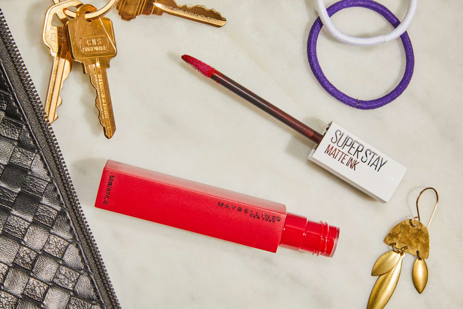 Maybelline SuperStay Matte Ink Liquid Lipstick sits on white counter with applicator out