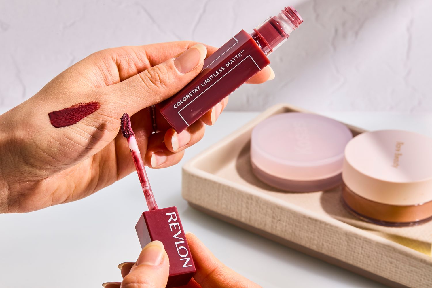 A person applies Revlon ColorStay Limitless Matte Liquid Lipstick to their hand