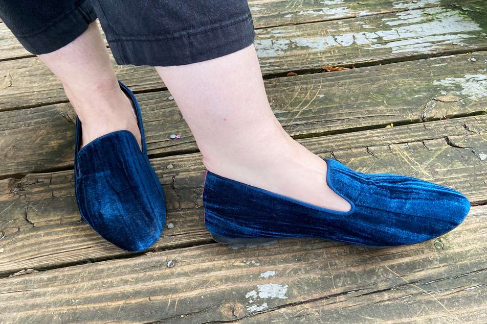 A person wearing Birdies The Starling Flats while standing on a wood deck
