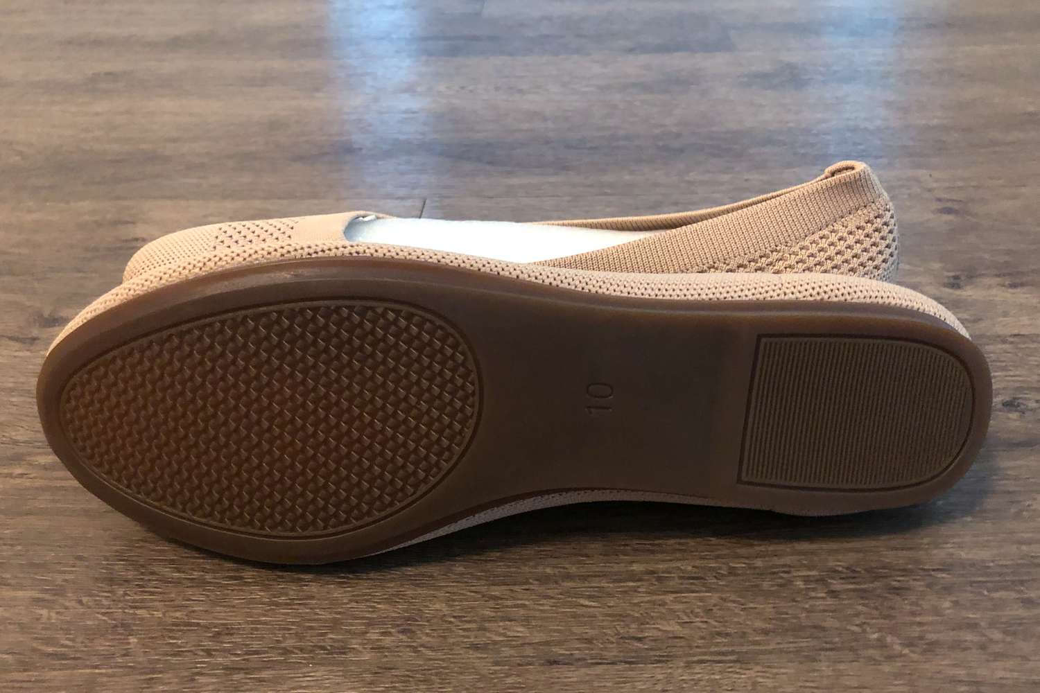 Bottom sole of a Frank Mully Round Toe Ballet Flat displayed on a wood floor