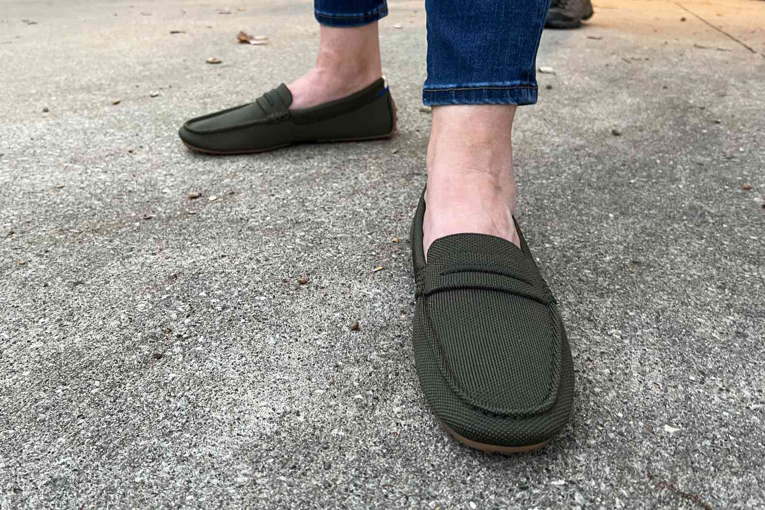 Feet wearing Rothy’s The Driver loafers on concrete