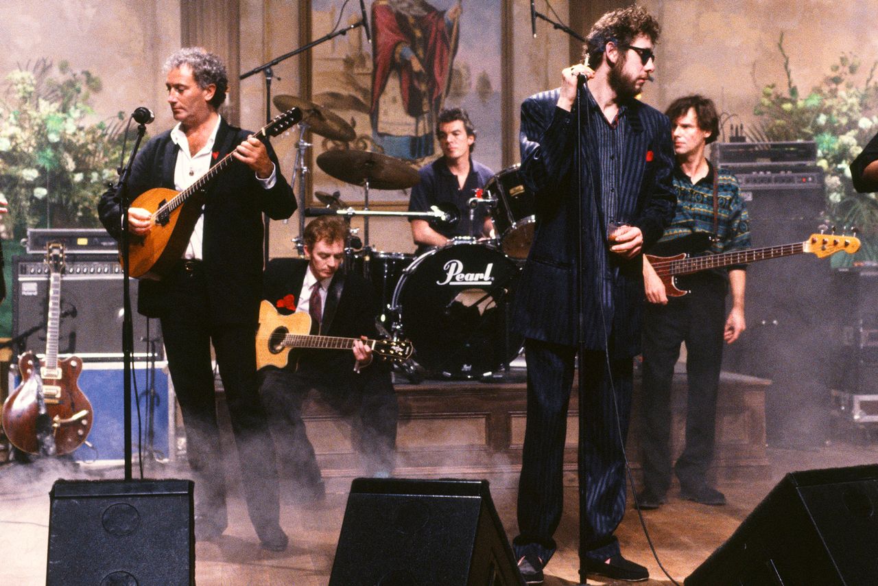 James Fearnley, Terry Woods, Philip Chevron, Andrew Ranken, Shane MacGowan, Darryl Hunt, Spider Stacy, Jem Finer of The Pogues performing on 'Saturday Night Live' in 1990 in N.Y.C. Alan Singer/NBCU Photo Bank/NBCUniversal via Getty