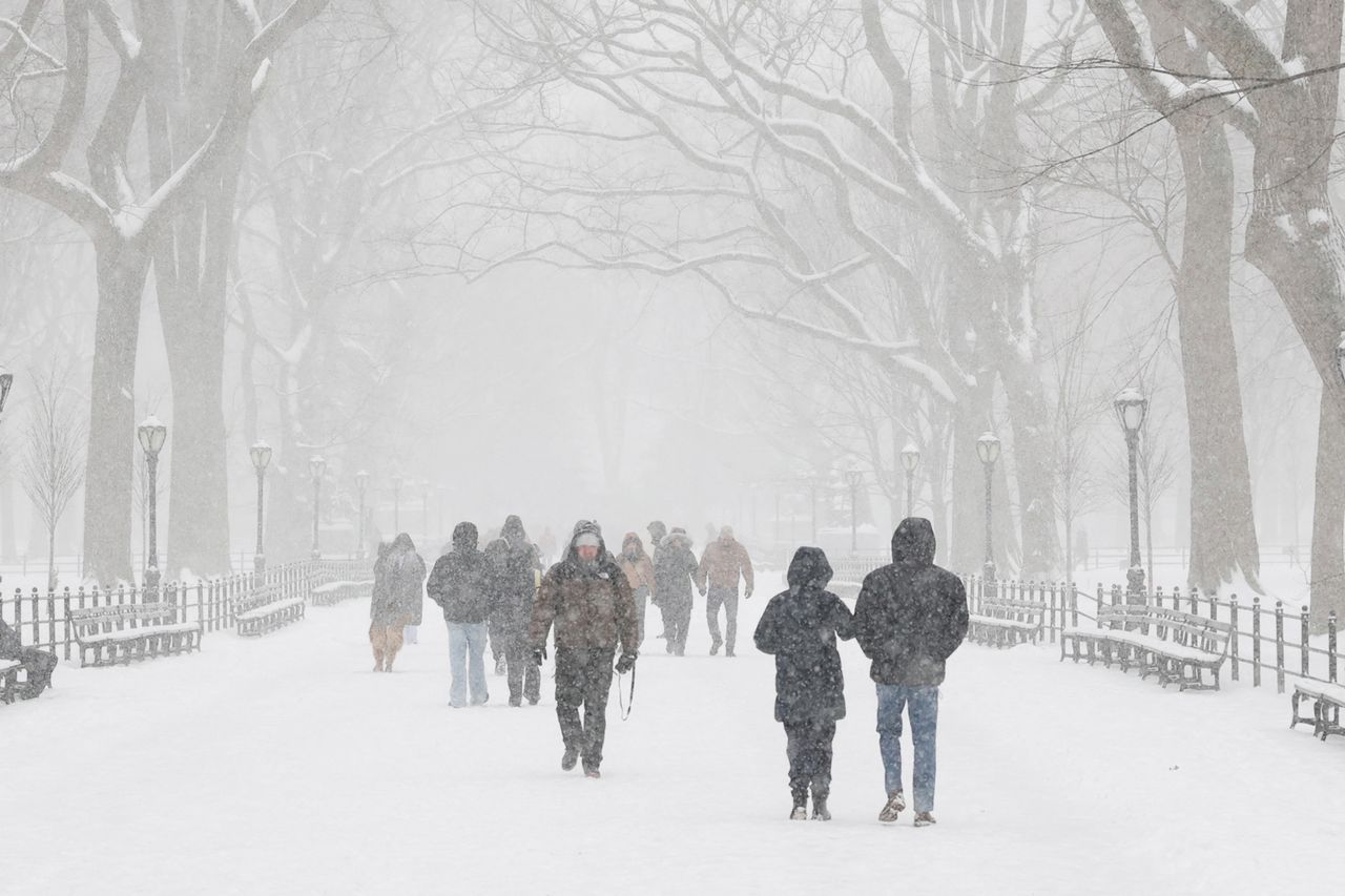 People walk in Central Park as snow falls in New York City on January 25, 2026.Credit: Timothy A. Clary/AFP/Getty