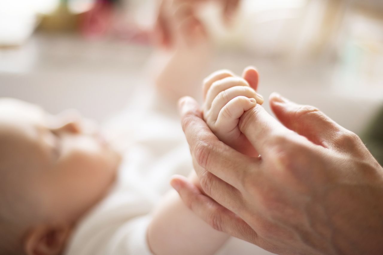 Baby and mum's hands - close-up Stock photo of a baby.Credit: Getty