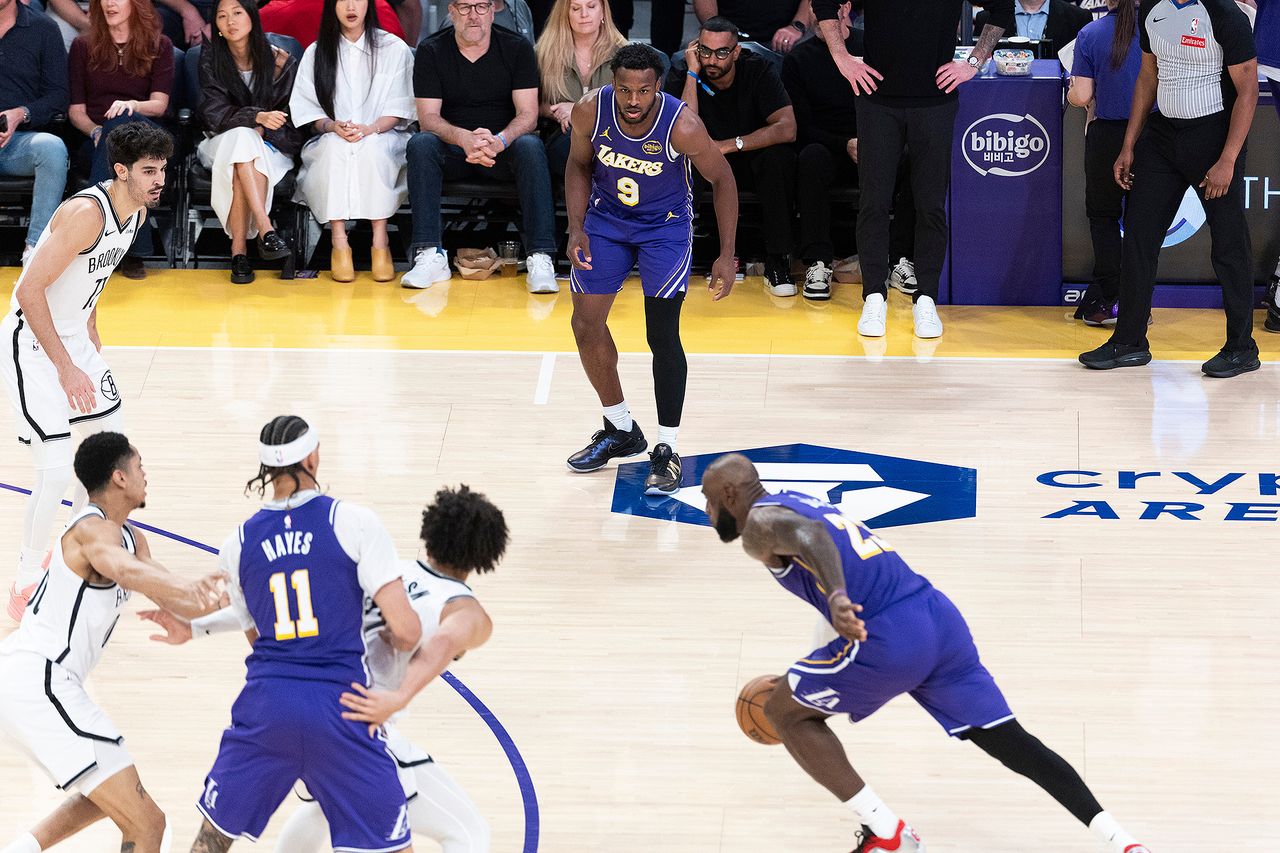 Bronny James watches his father LeBron James while with him at the Lakers' March 27 gameCredit: Ringo Chiu via AP