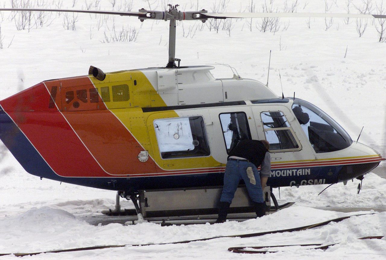 An employee places a rack on the side of a Selkirk Mountain helicopter in Revelstoke, B.C., Canada Helicopter mission.Credit: AP Photo/Canadian Press, Adrian Wyld