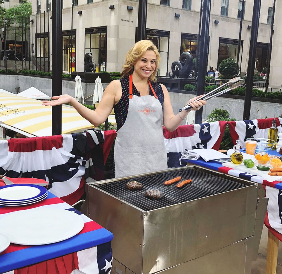 Celebrity chef Donatella Arpaia preparing hotdogs and hamburgers on a grill.Credit: Donatella Arpaia/Instagram