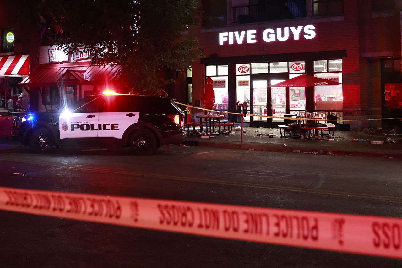 Police officers investigate the scene following a shooting on Kirkwood AvenueCredit: Jeremy Hogan/Getty