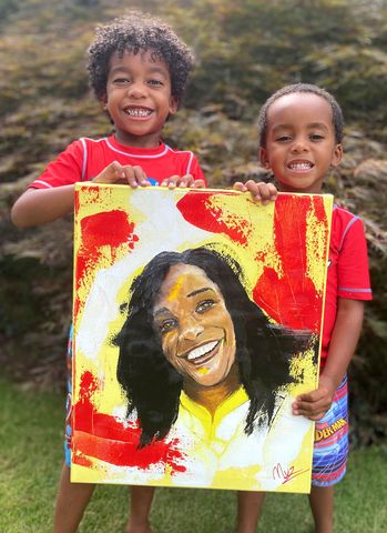 Charles Johnson's sons, Charles V and Langston, holding a portrait of their mom, KiraCredit: Demetrious Williams
