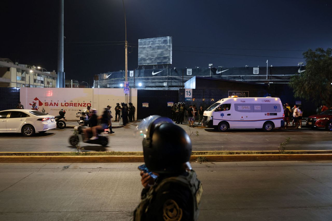 Police officers stand guard at the entrance of the Alejandro Villanueva Stadium while relatives wait for news after an accident in the stands where Alianza Lima's fans were cheering for their team on the eve of the match against Universitario in Lima on April 3, 2026. Emergency crews gather outside Alejandro Villanueva Stadium in Lima, Peru, on April 3, 2026Credit: Connie FRANCE / AFP via Getty