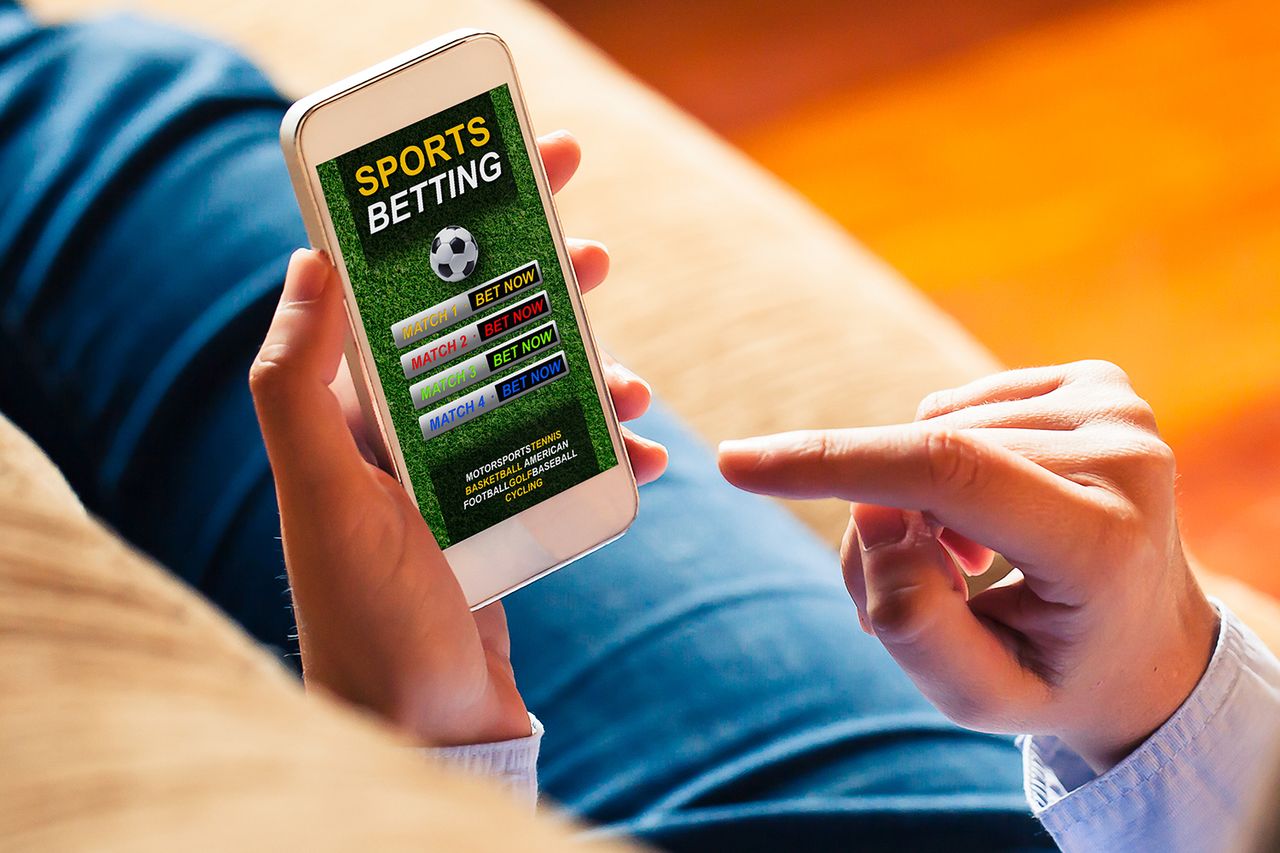 A generic photo of a person holding a phone with a sports betting app.Credit: Getty