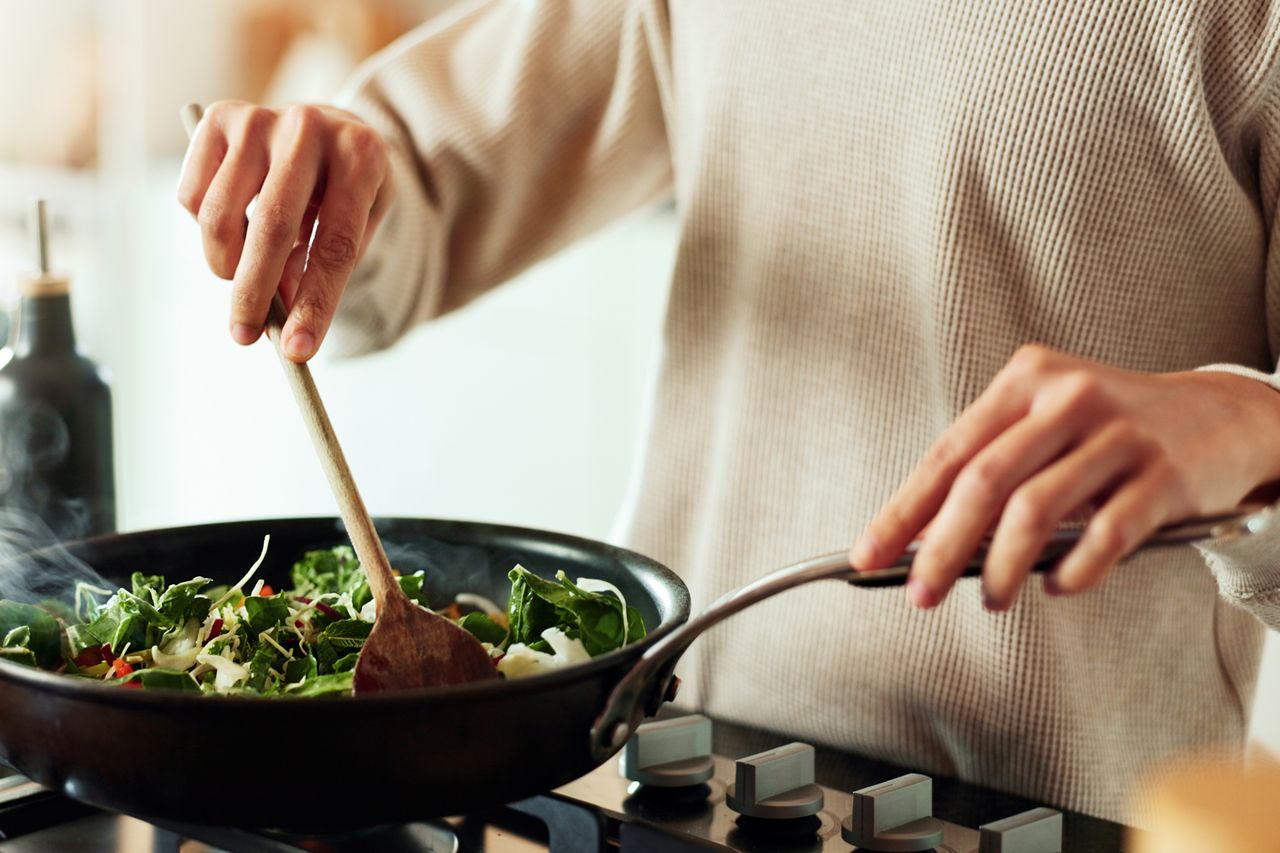 Stock image of a man cooking vegetablesCredit: Getty