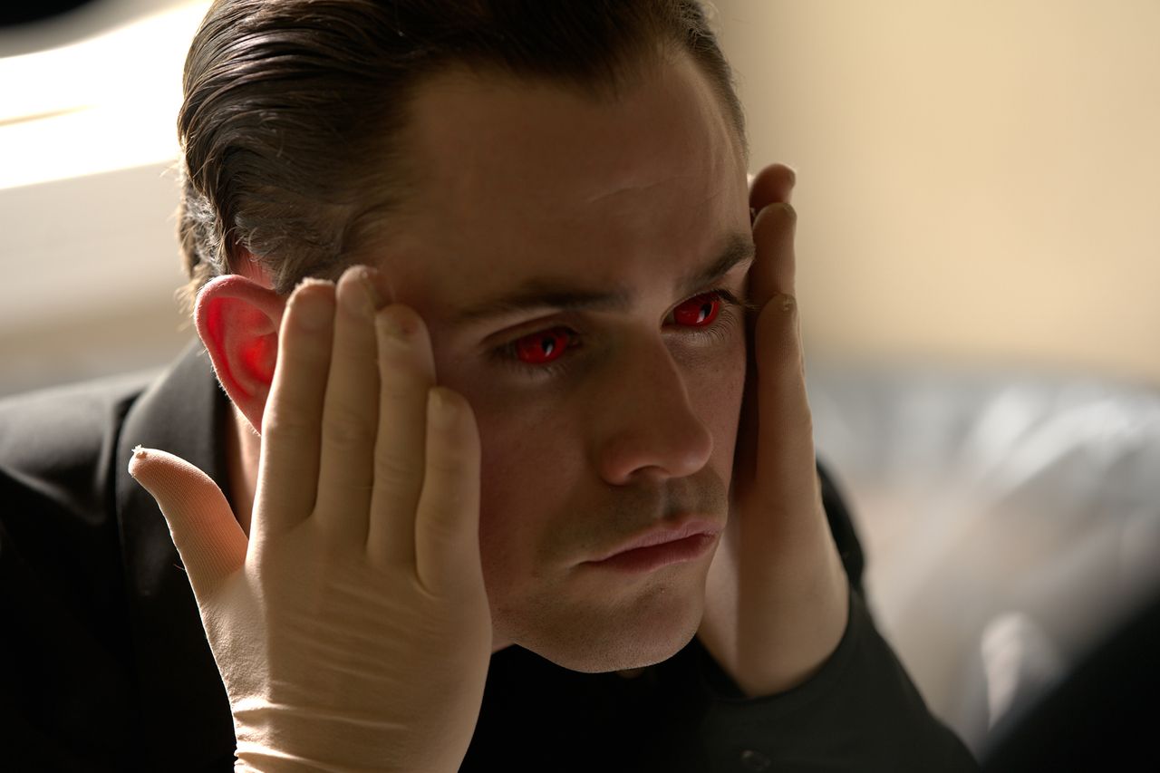 Dacre Montgomery with glowing red eyes holding his face with gloved hands Dacre Montgomery in 'Faces of Death'Credit: Courtesy of Independent Film Company and Shudder