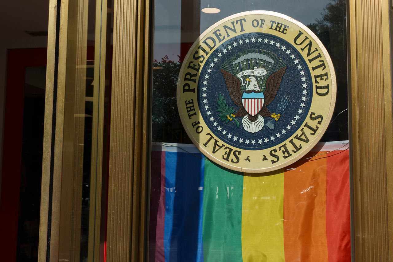 A Pride flag hang below a Presidential seal at a souvenir store along the WorldPride Parade route on June 7, 2025.Credit: Kevin Carter/Getty
