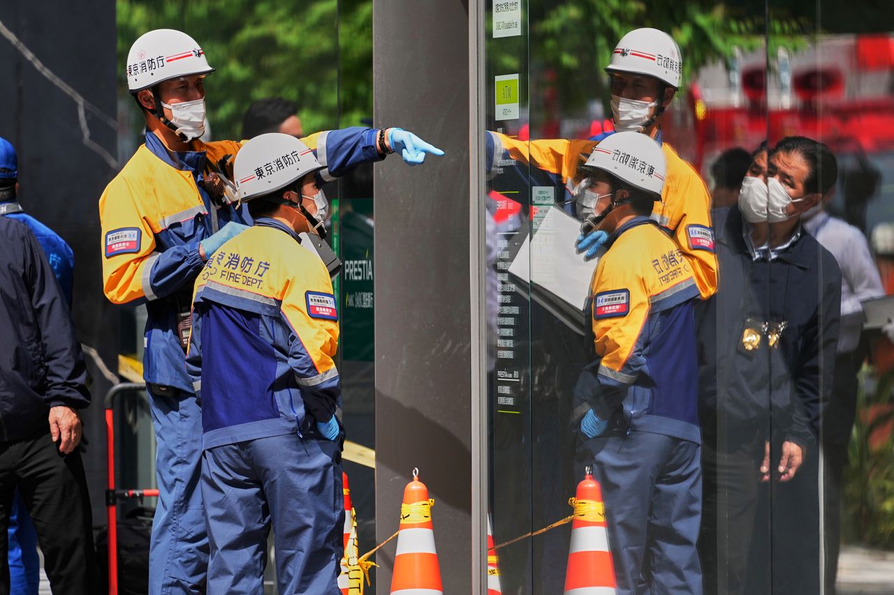 Tokyo Fire Department personnel examine the scene after a person allegedly sprayed a substance in a shopping center on MondayCredit: Eugene Hoshiko/AP