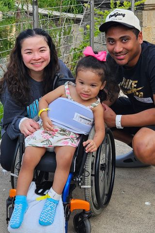 Two-year-old Milah ran around playing and jumping in-and-out of an inflatable pool at her dad's birthday party. When she woke from a nap, she couldn't stand, and when her parents had her walk, she limped. Her parents took her to the emergency room thinking maybe she had a sprained ankle. The next day, she couldn't even sit up, and soon she was paralyzed waist down. She was diagnosed with a spinal AVM. She had an 8-hour surgery, then months of rehab learning to walk again. Milah Faciane and her parents Linda Huynh and Blake Faciane in May 2025Credit: Courtesy of Linda Huynh and Blake Faciane