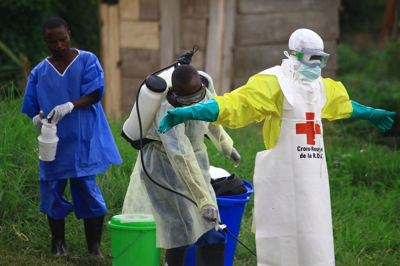 A health worker sprays disinfectant on his colleague after working at an Ebola treatment center in Beni, eastern CongoCredit: AP Photo/Al-hadji Kudra Maliro
