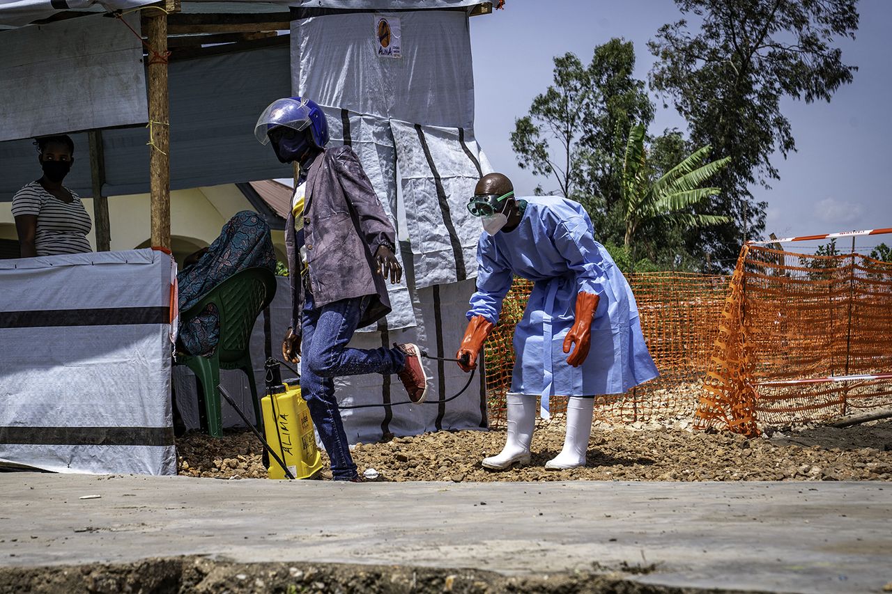Dieudonné Sezabo, a health worker, decontaminates the clothing of a motorcycle taxi driver who transported a patient suspected of having Ebola to the Rwampara Hospital in Ituri A health worker cleans the clothing of a taxi driver in the Democratic Republic of the Congo (DRC)Credit: Glody MURHABAZI / AFP via Getty