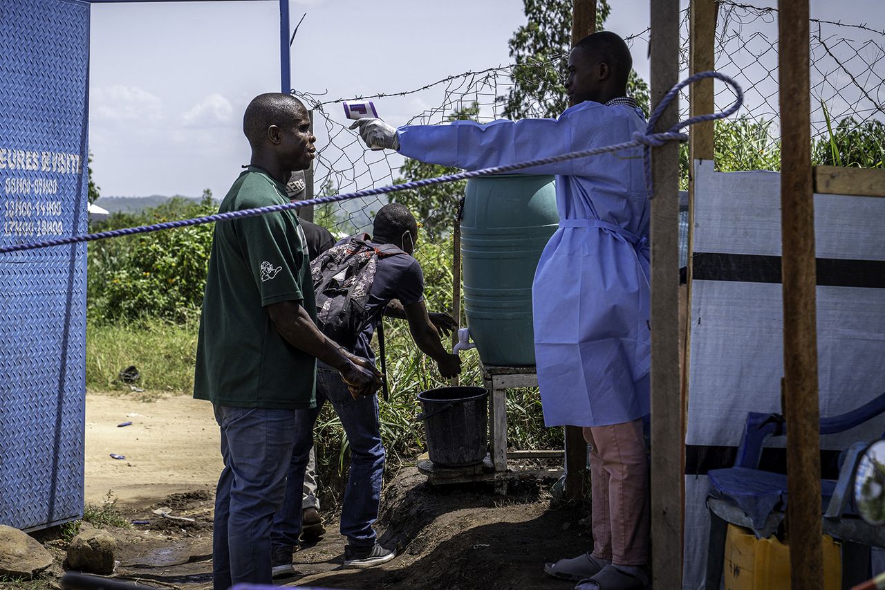 A healthcare worker takes a visitor's temperature at Rwampara Hospital in Ituri A healthcare worker takes a person's temperature in the DRCCredit: Glody MURHABAZI / AFP via Getty