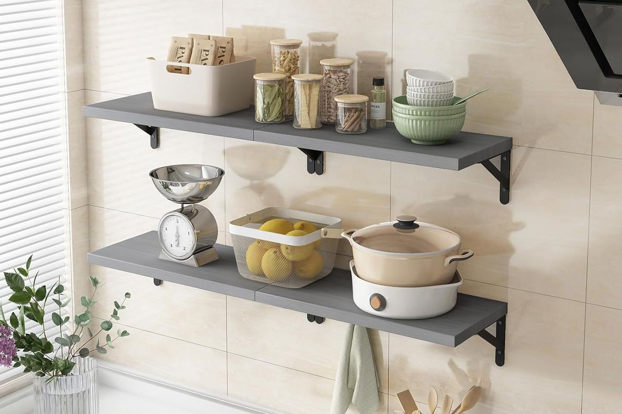 Two floating shelves holding kitchen items such as jars bowls a scale and a pot mounted on a tiled wall Credit: Amazon