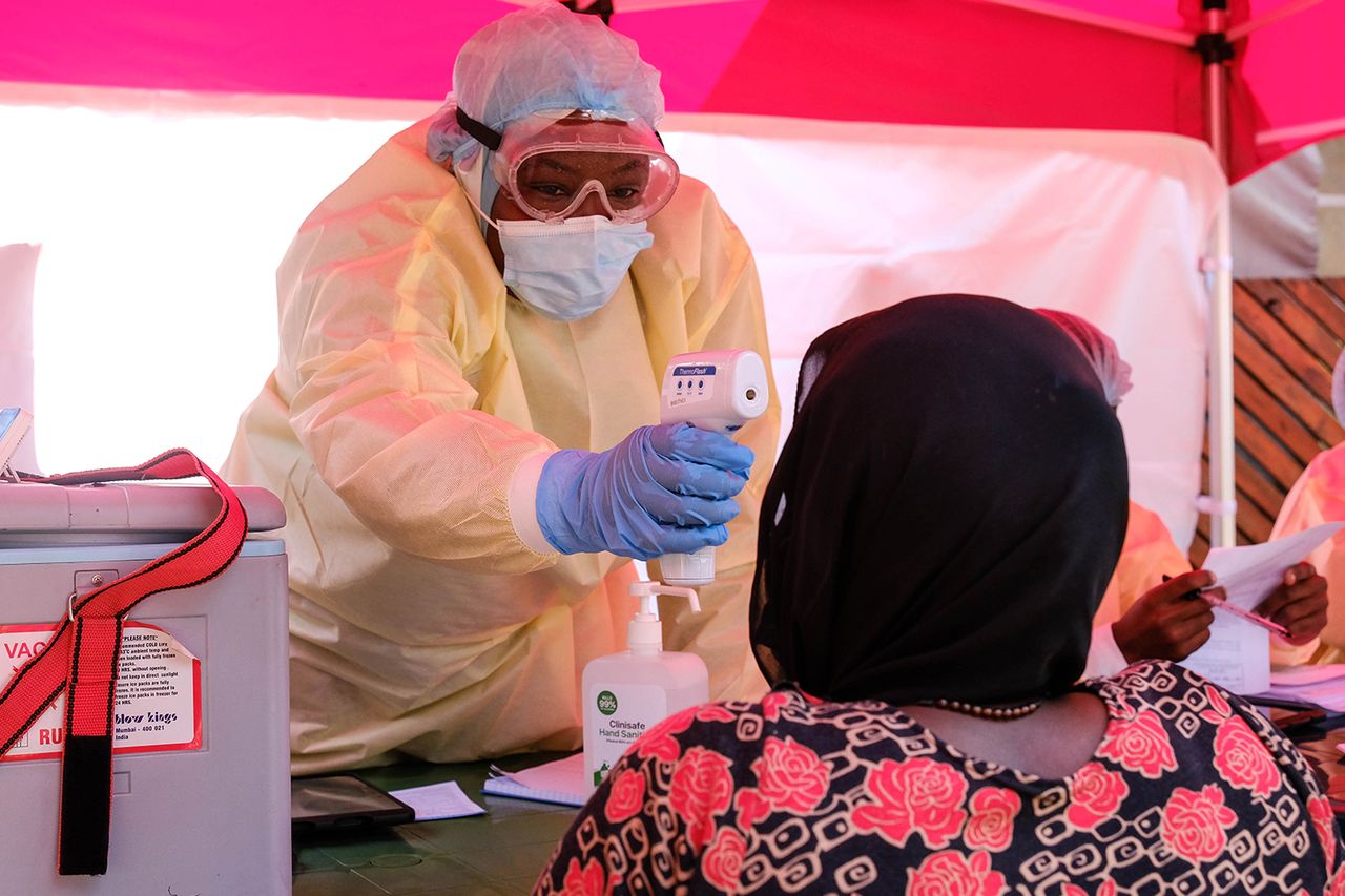 A health worker takes the temperature of a patientCredit: Hajarah Nalwadda/Getty
