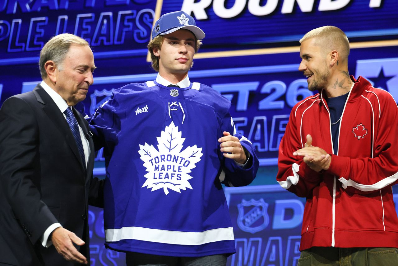 NHL commissioner Gary Bettman looks on as Gavin McKenna of Canada and singer Justin Bieber look on after McKenna was drafted by the Toronto Maple Leafs with the first overall pick during day one of the 2026 NHL DraftCredit: Bruce Bennett/Gett