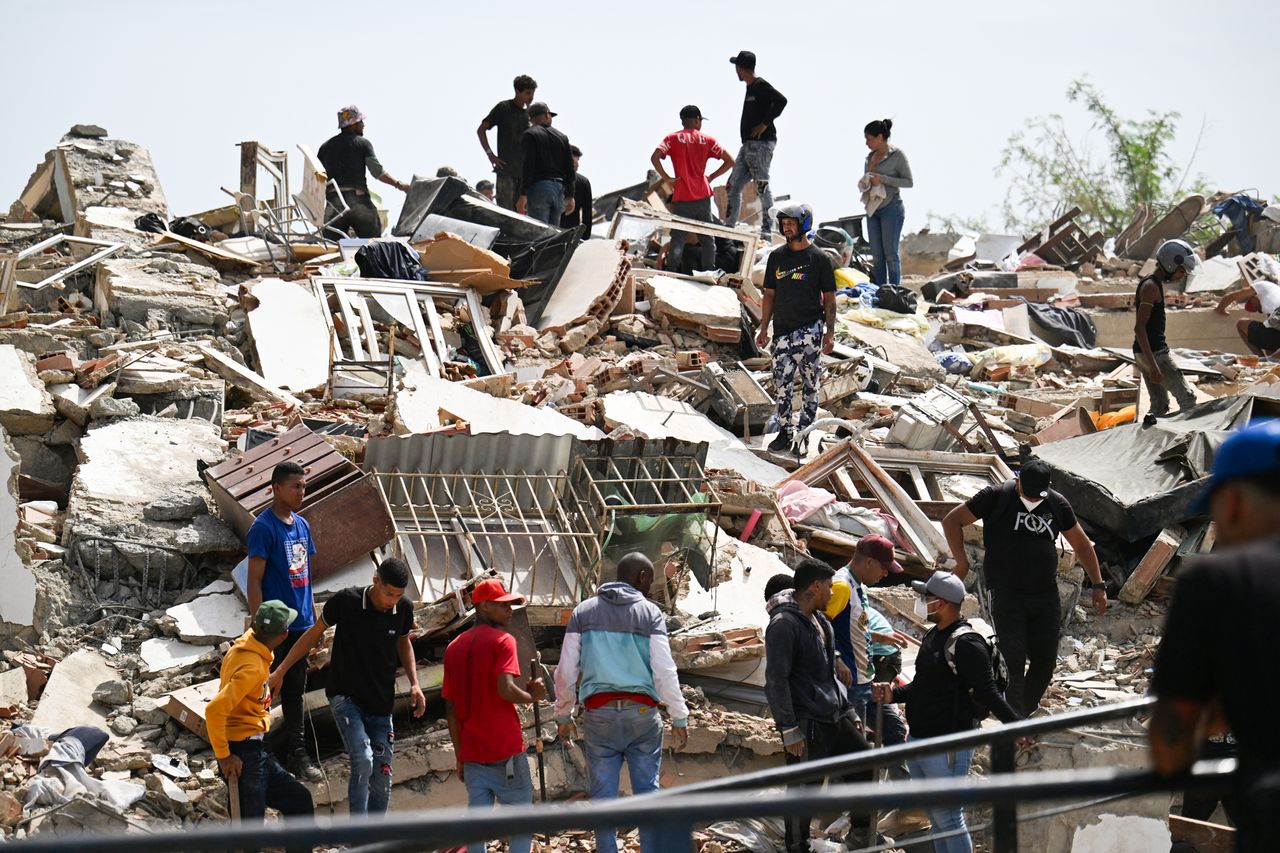 Residents search for victims through the rubble of a collapsed building in Catia La Mar, La Guaira state on June 25Credit: Juan BARRETO / AFP via Getty