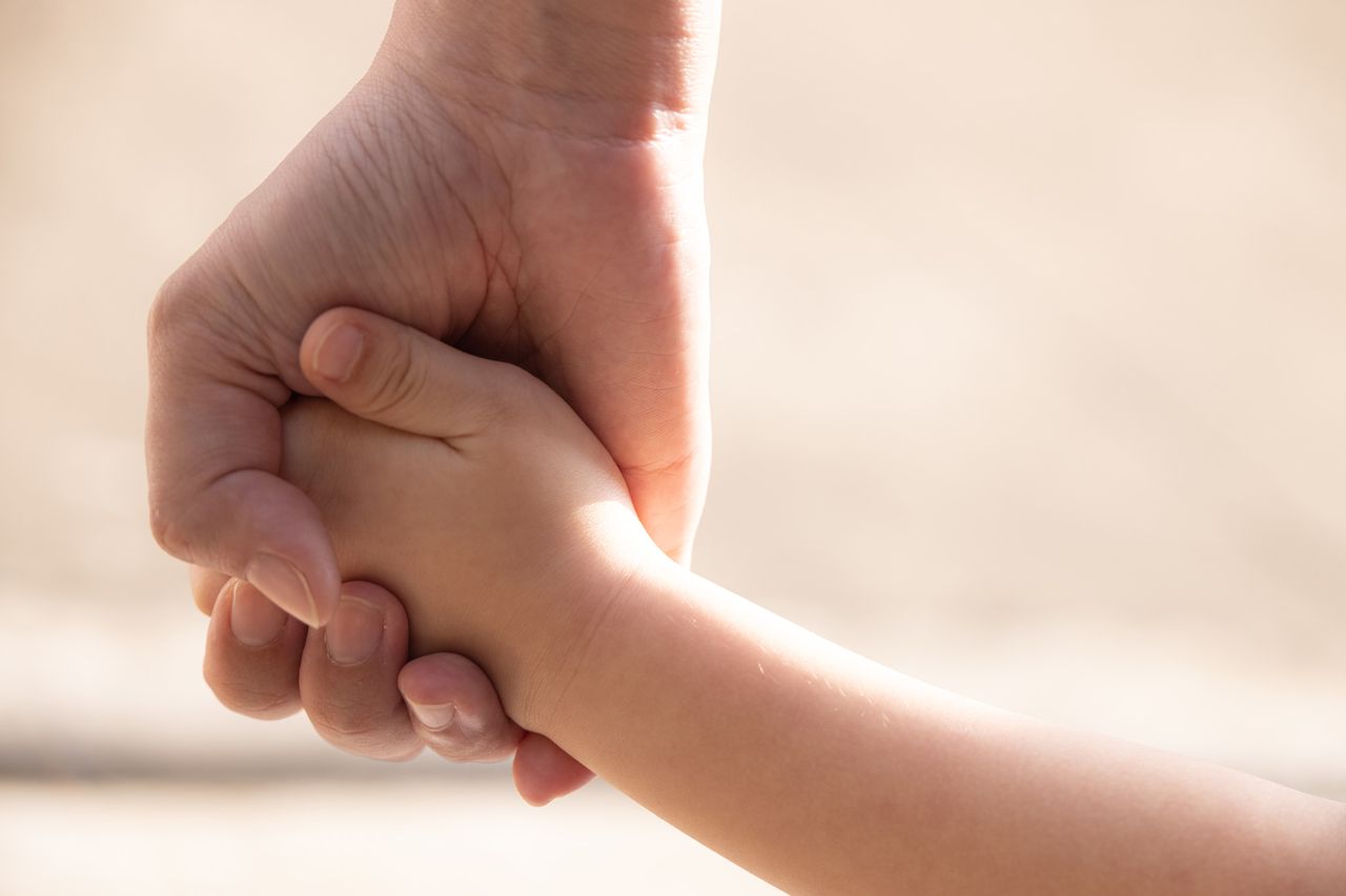 Stock image of a mother holding her child's handCredit: Getty