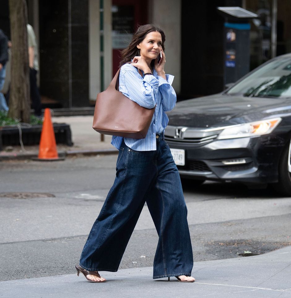 Katie Holmes walking on a sidewalk carrying a brown tote bag Credit: Michael Simon/WireImage