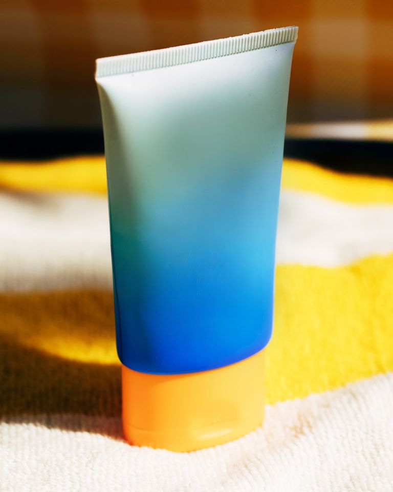 A tube of sunscreen on a yellow towel A sunscreen bottleCredit: Viktoriya Skorikova/Moment RF/Getty