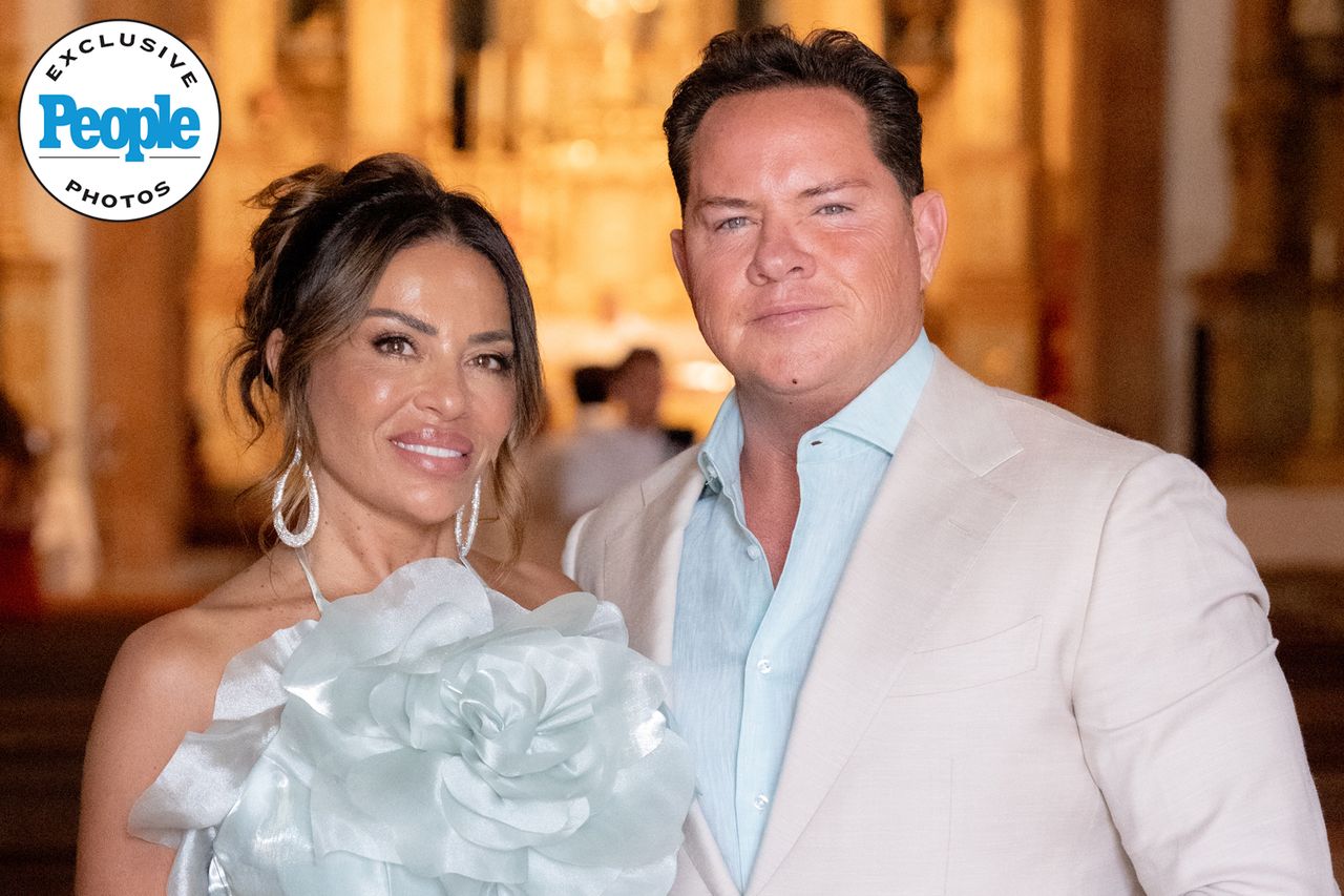 A couple posing at an event dressed formally with a decorative background Dolores Catania and Paulie ConnellCredit: Michael Zennaro Photography