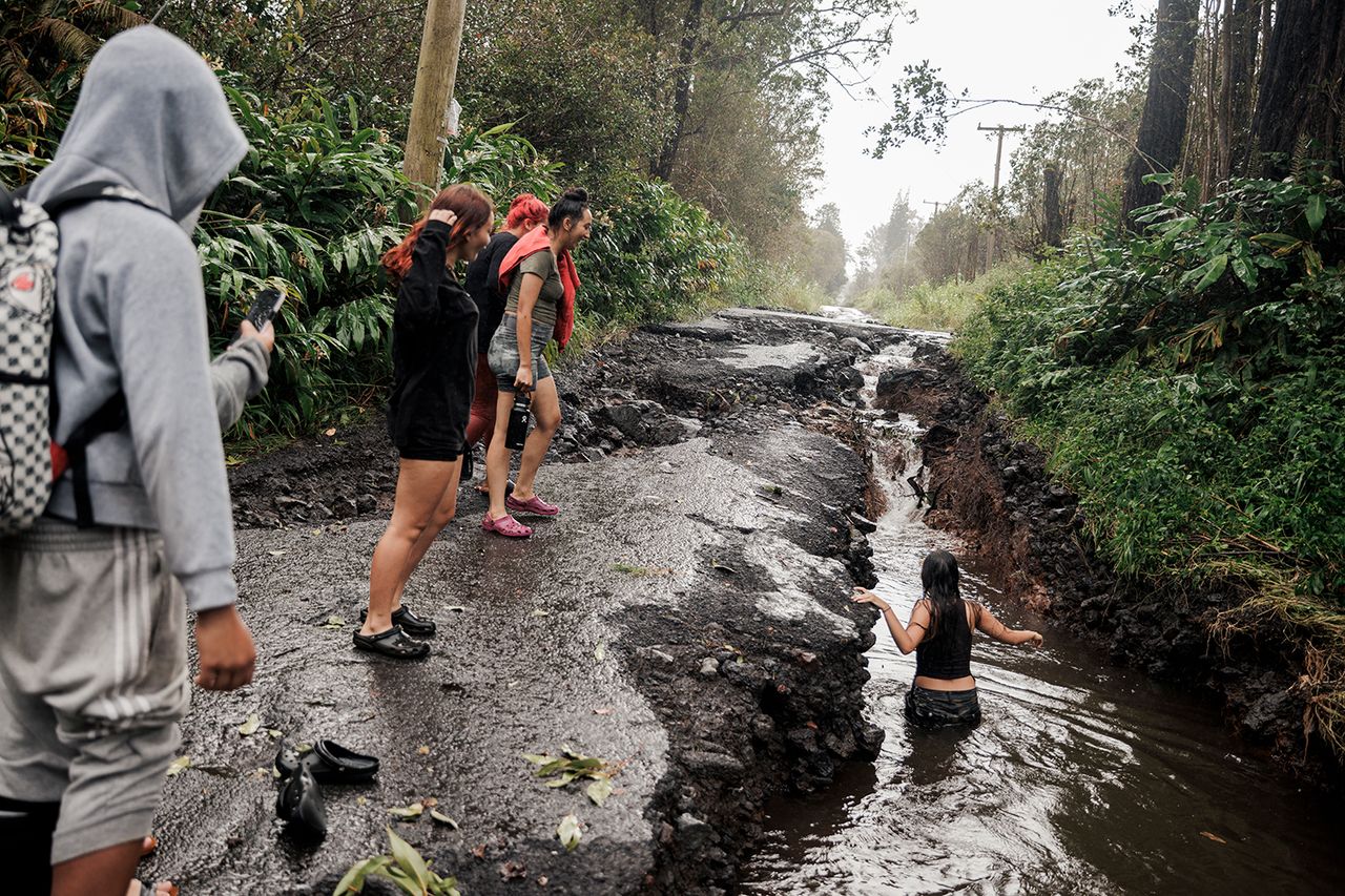A teenager wades through a pool of water in Mountain View, Hawaii, Sunday, Aug. 16, 2026.Credit: Stephen Lam/San Francisco Chronicle/Getty