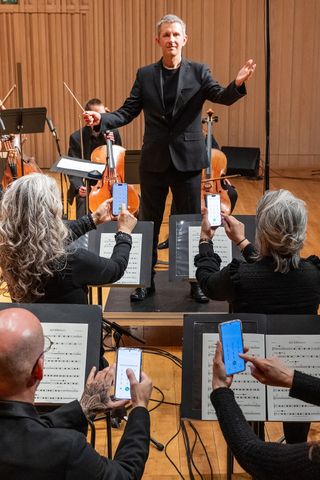 Tim Crooks conducts the four-piece phone section of his Manchester Camerata chamber orchestraCredit: KENNEDY NEWS