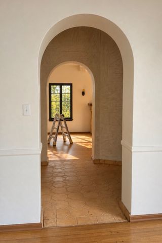 An empty room viewed through an archway with a ladder near a window in the background Ravnik’s new homeCredit: Jan Ravnik/instagram